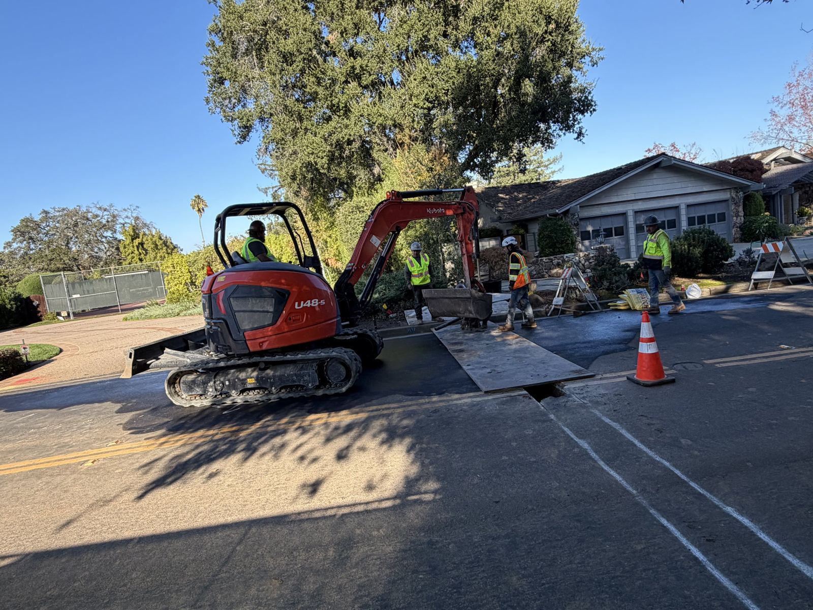 Mini excavator digging a trench in the street