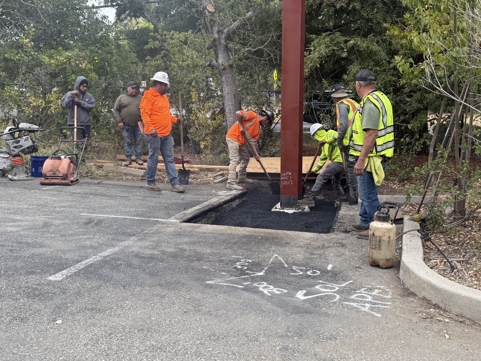 Crew patching asphalt in a Palo Alto parking lot