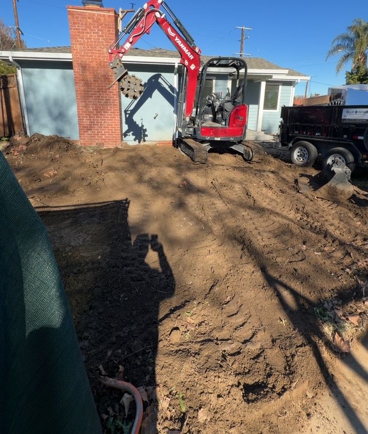 Mini excavator with compaction wheel at a residential job