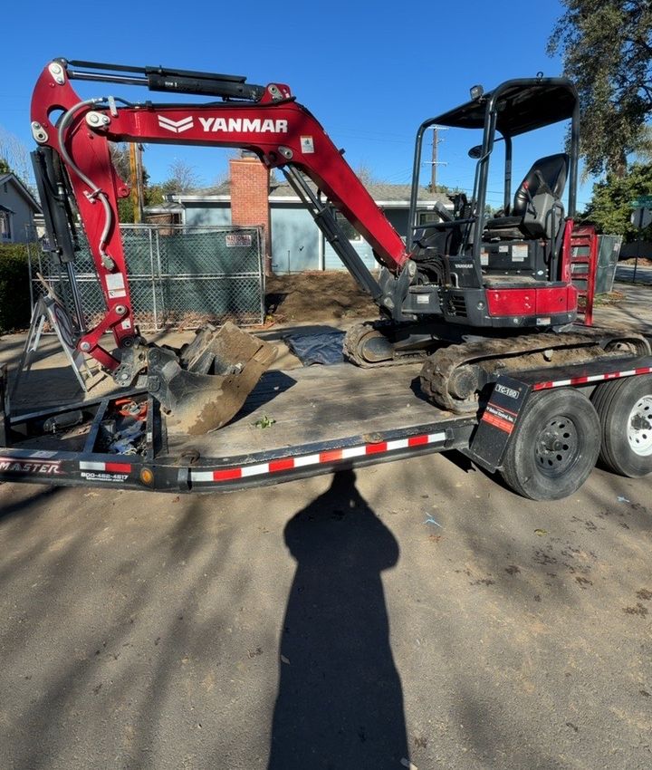 Mini excavator on trailer at a San Jose job site
